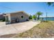 Rear exterior view featuring a large driveway leading to a lake view beyond the house at 5020 Old Lucerne Park Rd, Winter Haven, FL 33881