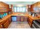 Charming kitchen featuring unique wood cabinets, tile countertops, and a large window overlooking the water at 5020 Old Lucerne Park Rd, Winter Haven, FL 33881