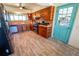 Well-equipped kitchen with unique wood cabinetry, modern appliances, and a vibrant teal door at 5020 Old Lucerne Park Rd, Winter Haven, FL 33881