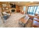 Bright living room featuring a stone fireplace, wood walls, light floors, and sliding glass doors to outdoor space at 5020 Old Lucerne Park Rd, Winter Haven, FL 33881