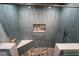 Modern shower featuring blue tiling, a built-in seat, and pebble tile accents at 5020 Old Lucerne Park Rd, Winter Haven, FL 33881