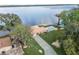 Aerial shot of a home, pool and pier situated on a large lake under a partly cloudy sky at 830 County Rd 457, Lake Panasoffkee, FL 33538
