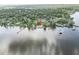 Stunning aerial perspective of a home with lake access featuring docks and lush greenery under a partly cloudy sky at 830 County Rd 457, Lake Panasoffkee, FL 33538