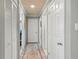 Neutral hallway with hardwood flooring and several white doors at 830 County Rd 457, Lake Panasoffkee, FL 33538