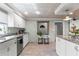Bright kitchen featuring granite countertops, wood floors, and stainless steel appliances at 830 County Rd 457, Lake Panasoffkee, FL 33538