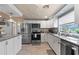 Bright kitchen featuring granite countertops, wood floors, and stainless steel appliances at 830 County Rd 457, Lake Panasoffkee, FL 33538