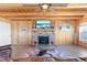 Living room featuring a brick fireplace with mounted TV, lake view, and wooden interior at 830 County Rd 457, Lake Panasoffkee, FL 33538