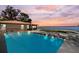 Backyard pool overlooking peaceful water with a beautiful sunset view, and outdoor seating at 830 County Rd 457, Lake Panasoffkee, FL 33538