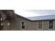A low-angle shot of the house showing windows and the light metal roof at 102 Se 6Th Ave, Mulberry, FL 33860