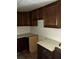Basic kitchen with dark wood cabinets, simple countertops, and functional layout, ready for renovation at 102 Se 6Th Ave, Mulberry, FL 33860