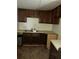 Functional kitchen with dark wood cabinets, double sink, and simple countertops, ready for customization at 102 Se 6Th Ave, Mulberry, FL 33860
