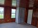 Cozy living room features wood-paneled walls, light carpet, and bright windows looking out to the lawn at 102 Se 6Th Ave, Mulberry, FL 33860
