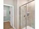 Bathroom with a glass enclosed shower, tile surround, and view into adjacent room at 1906 Clear Sky Dr, Kissimmee, FL 34744