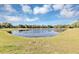 Scenic view of a tranquil community pond surrounded by lush green grass at 1906 Clear Sky Dr, Kissimmee, FL 34744