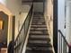 A luxurious staircase with sleek black steps, complemented by elegant marble-style walls and classic white columns at 254 Chelsea Ave, Davenport, FL 33837