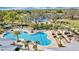 Aerial view of a resort-style community pool, palm trees, lounge seating, and a splash pad at 2652 Peace Of Mind Ave, Kissimmee, FL 34744