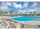 Luxury community pool with lounge chairs, palm trees, and a sun-drenched pool house at 2652 Peace Of Mind Ave, Kissimmee, FL 34744