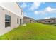 Spacious backyard with lush green grass, a patio set, and the home's exterior featuring grey tones at 1532 Axel Cir, Winter Haven, FL 33880