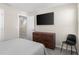 Bedroom with neutral walls and carpet, features TV mounted on wall and a view into the hallway at 1532 Axel Cir, Winter Haven, FL 33880
