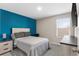 Comfortable carpeted bedroom features a contemporary bed, side table, desk and stylish blue accent wall at 1532 Axel Cir, Winter Haven, FL 33880