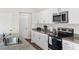 Stylish kitchen featuring stainless steel appliances, granite countertops, white cabinets, and a stainless steel sink at 1532 Axel Cir, Winter Haven, FL 33880