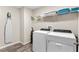 Laundry room with washer, dryer, shelving, ironing board, and wood-look flooring for added style at 1532 Axel Cir, Winter Haven, FL 33880