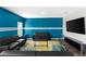 Modern living room featuring a striking blue accent wall, sleek furniture, and bright natural light at 1532 Axel Cir, Winter Haven, FL 33880