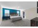 Bright main bedroom featuring a large bed, workspace, and blue accent wall at 1532 Axel Cir, Winter Haven, FL 33880