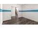 Open room with stylish wood flooring and a blue accent stripe leading to the staircase at 1532 Axel Cir, Winter Haven, FL 33880