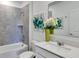 Stylish bathroom with a single sink, white cabinets, and a tiled shower-tub combination at 5618 Gingham Dr, Kissimmee, FL 34758