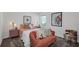 Bright bedroom featuring a bed with a peach cover, a couch, and modern wall decor at 5618 Gingham Dr, Kissimmee, FL 34758