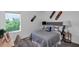 Comfortable bedroom featuring a bed with gray bedding, decorative skateboards, and a modern desk at 5618 Gingham Dr, Kissimmee, FL 34758