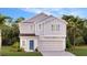 Charming two-story home featuring a light gray exterior, a blue door and a well-manicured lawn at 5618 Gingham Dr, Kissimmee, FL 34758