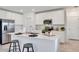 Modern white kitchen featuring a large island, stainless steel appliances, and a sleek design at 5618 Gingham Dr, Kissimmee, FL 34758