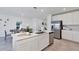 Open kitchen with white cabinets, stainless steel appliances, and a large center island at 5618 Gingham Dr, Kissimmee, FL 34758