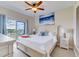 Bright bedroom features a ceiling fan, a serene painting, and a private balcony with a lovely view at 13415 Blue Heron Beach Dr # 1201, Orlando, FL 32821