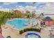 Large community pool with bar, hot tub, lounge chairs and palm trees at 13415 Blue Heron Beach Dr # 1201, Orlando, FL 32821