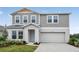 Charming two-story home with light gray siding, a well-manicured lawn, and an attached two-car garage at 1014 Foreshore Ln, Haines City, FL 33844