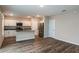 Open concept kitchen with white cabinets, stainless steel appliances, wood-look floors, and an island with seating at 1014 Foreshore Ln, Haines City, FL 33844