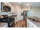 Modern kitchen with white cabinets, stainless steel appliances, an island with seating, and wood-look floors at 1014 Foreshore Ln, Haines City, FL 33844
