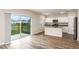 Open-concept kitchen with white cabinets, a center island, stainless steel appliances, and sliding glass doors to the backyard at 1014 Foreshore Ln, Haines City, FL 33844