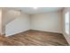 Bright living room with wood-look floors, neutral walls, a staircase, and a large window at 1014 Foreshore Ln, Haines City, FL 33844