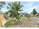 Spacious backyard featuring mature landscaping and a charming white picket fence, perfect for outdoor activities at 122 2Nd Jpv St, Winter Haven, FL 33880
