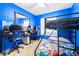 Blue bedroom with a bunk bed, carpet, and a desk setup for gaming at 122 2Nd Jpv St, Winter Haven, FL 33880