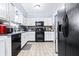 Well-lit kitchen featuring white cabinetry, black appliances, and tile floors at 122 2Nd Jpv St, Winter Haven, FL 33880