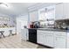 Bright kitchen boasts white cabinets, stainless steel sink and modern appliances at 122 2Nd Jpv St, Winter Haven, FL 33880