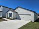 A newly built single-Gathering home featuring an attached two-car garage, concrete driveway and manicured landscaping at 1649 Nantucket Way, Winter Haven, FL 33884