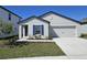 Charming single-Gathering home with a freshly landscaped yard, an attached two-car garage and dark blue door and shutters at 1649 Nantucket Way, Winter Haven, FL 33884
