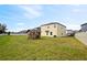 Backyard showcasing a wooden playhouse and fenced in lawn at 1773 Yellow Trl, Lakeland, FL 33801