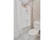 Bathroom with white tiled shower-tub combo and toilet with neutral walls at 1773 Yellow Trl, Lakeland, FL 33801
